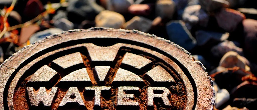 Metal cover labeled "water" at ground level.