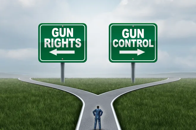 Illustration of a person on a road with diverging paths. Two signs are on the horizon. On the left is a sign with an arrow pointing left reading "gun rights." On the right is a sign with an arrow pointing right reading "gun control."